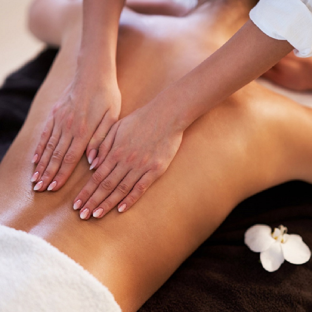 Relaxed woman receiving back massage